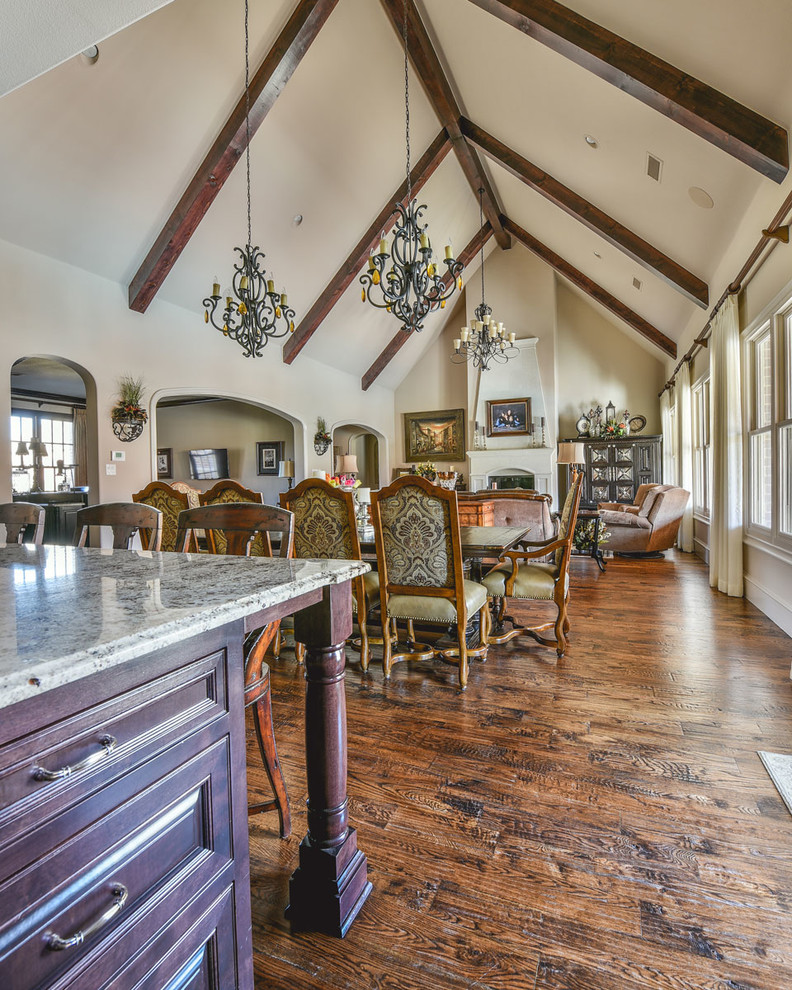 Foto de comedor clásico renovado grande abierto con paredes beige, suelo de madera en tonos medios, todas las chimeneas y marco de chimenea de piedra
