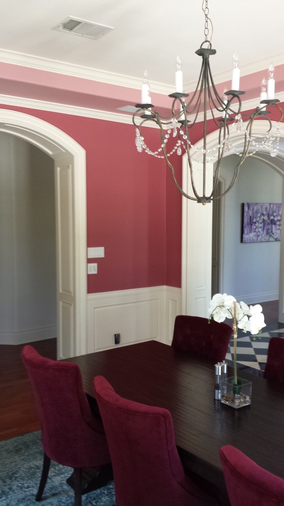 Geschlossenes, Mittelgroßes Klassisches Esszimmer ohne Kamin mit roter Wandfarbe, braunem Holzboden und braunem Boden in Austin
