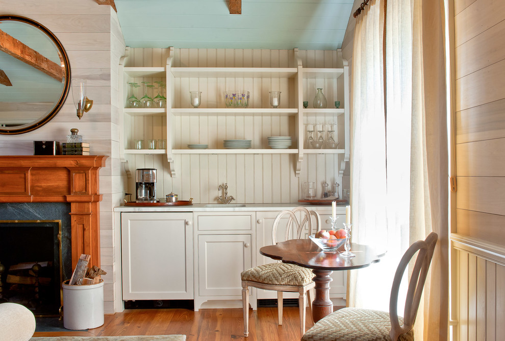 Idee per una sala da pranzo aperta verso il soggiorno tradizionale con pareti beige, pavimento in legno massello medio e camino classico