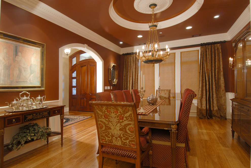 Inspiration for a timeless medium tone wood floor enclosed dining room remodel in Other with brown walls