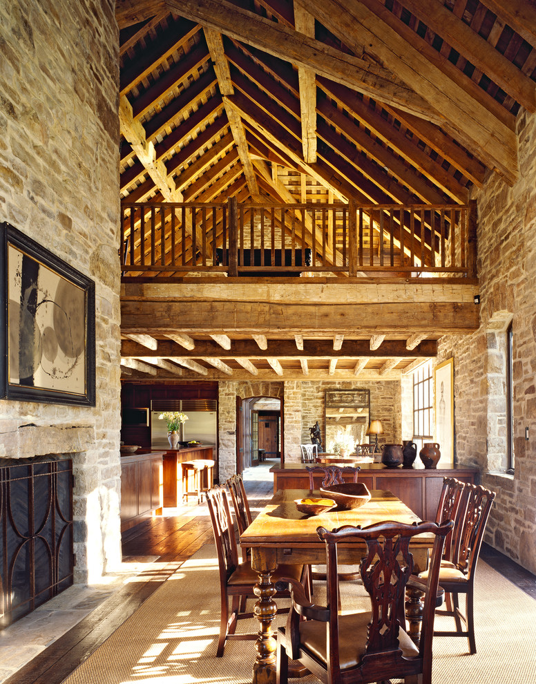 Idée de décoration pour une salle à manger tradition avec parquet foncé, une cheminée standard et un manteau de cheminée en pierre.