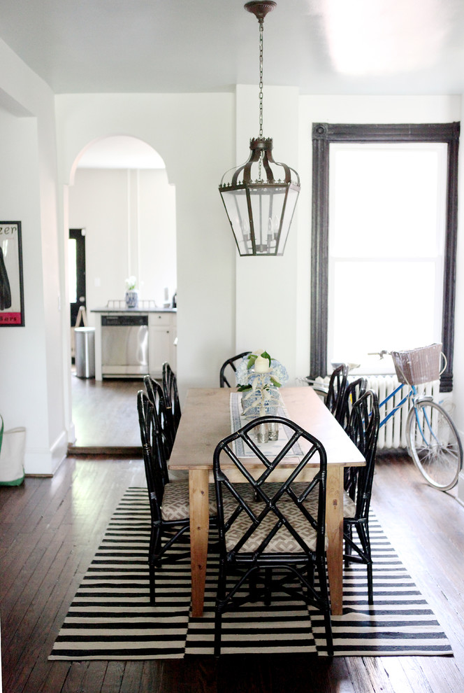 Exemple d'une salle à manger chic avec un mur blanc et parquet foncé.