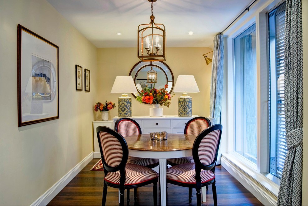 Design ideas for a classic dining room in London with yellow walls, dark hardwood flooring and feature lighting.
