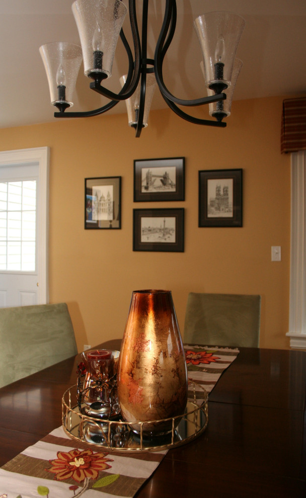 На фото: кухня-столовая среднего размера в классическом стиле с желтыми стенами, полом из бамбука и коричневым полом
