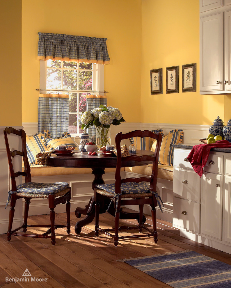 Idées déco pour une salle à manger ouverte sur la cuisine classique avec un mur multicolore et parquet clair.