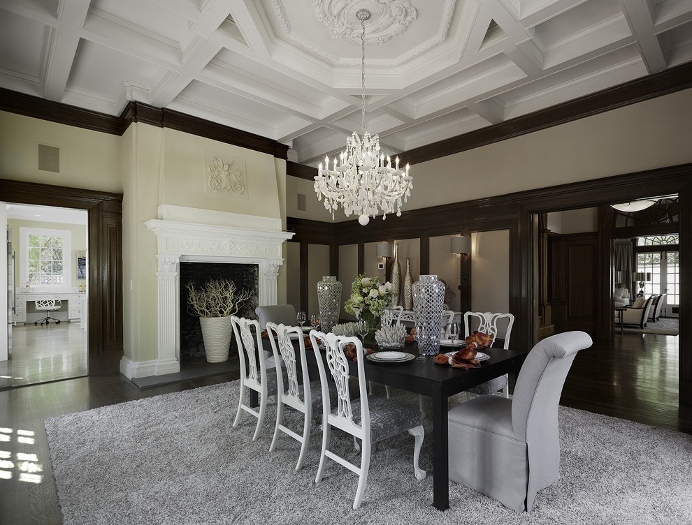 Aménagement d'une salle à manger classique avec un mur beige, parquet foncé et une cheminée standard.