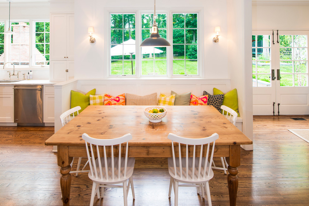 Immagine di una sala da pranzo aperta verso la cucina tradizionale con pareti bianche e parquet scuro