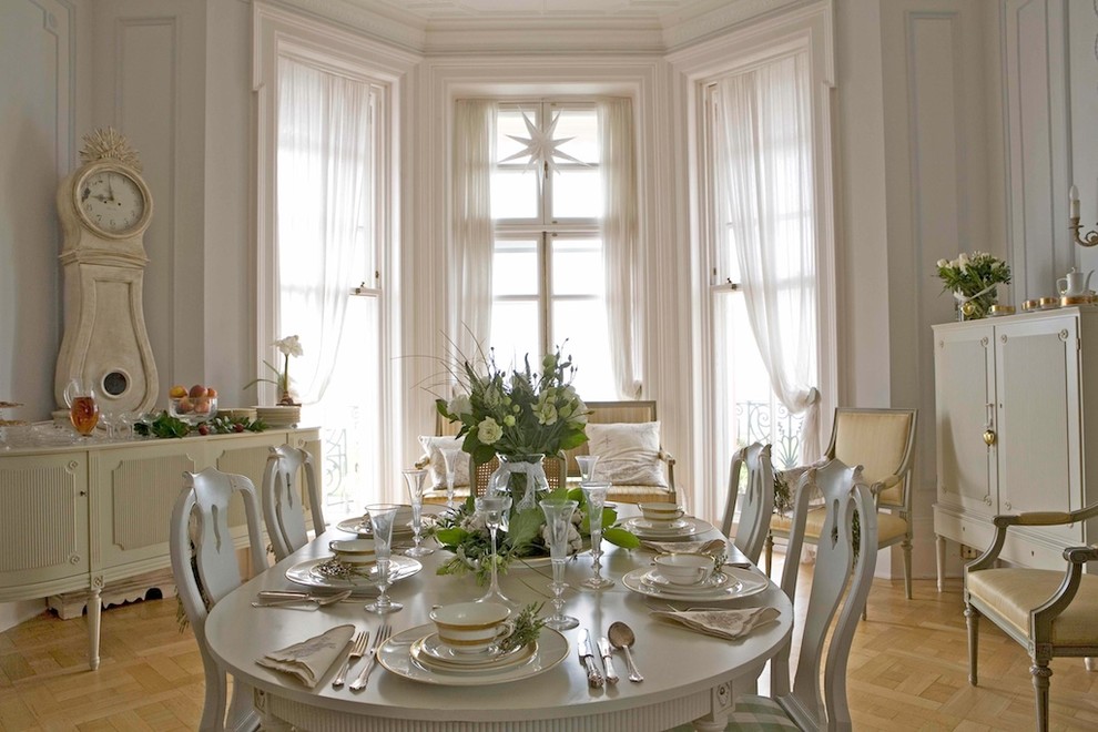 Example of a classic medium tone wood floor dining room design in Other with white walls