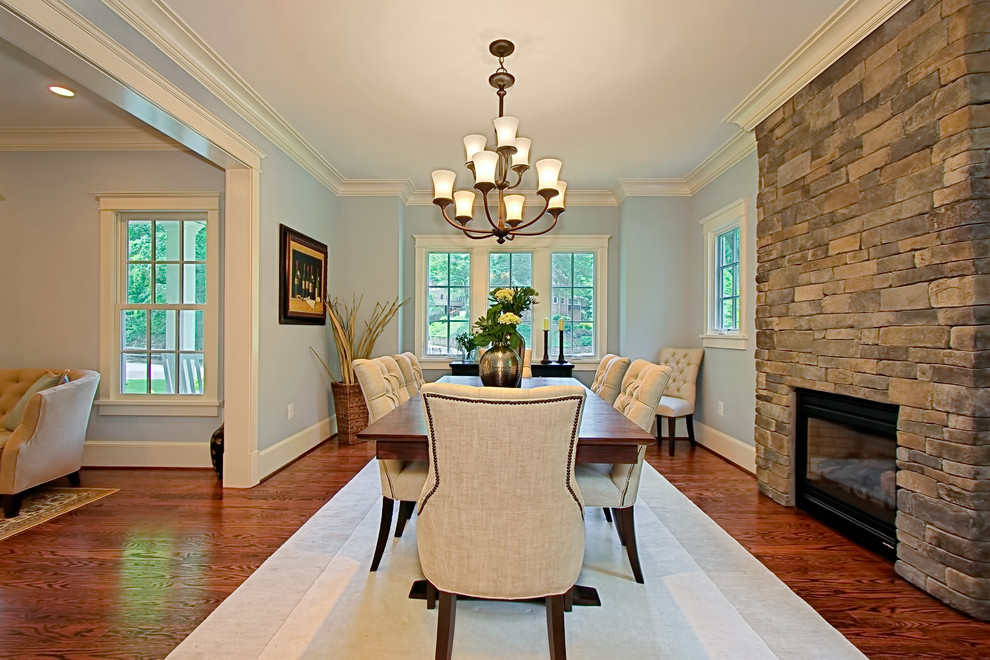 Traditional dining room in DC Metro with blue walls, dark hardwood flooring, a standard fireplace and a stone fireplace surround.