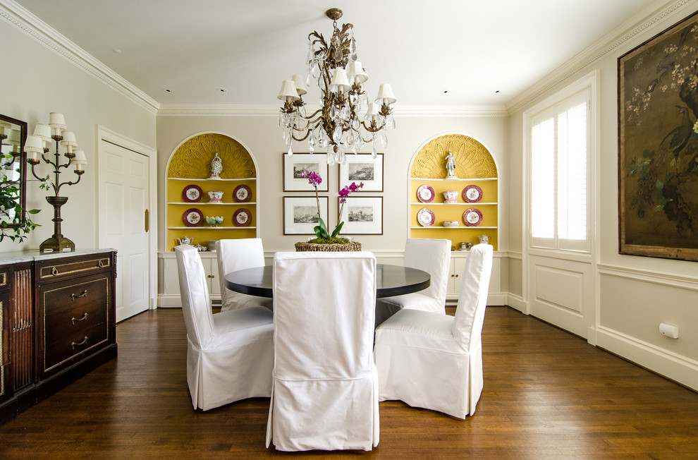 Aménagement d'une salle à manger classique avec un mur blanc et parquet foncé.
