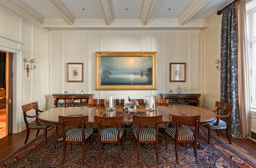 This is an example of a classic dining room in New York with beige walls and dark hardwood flooring.