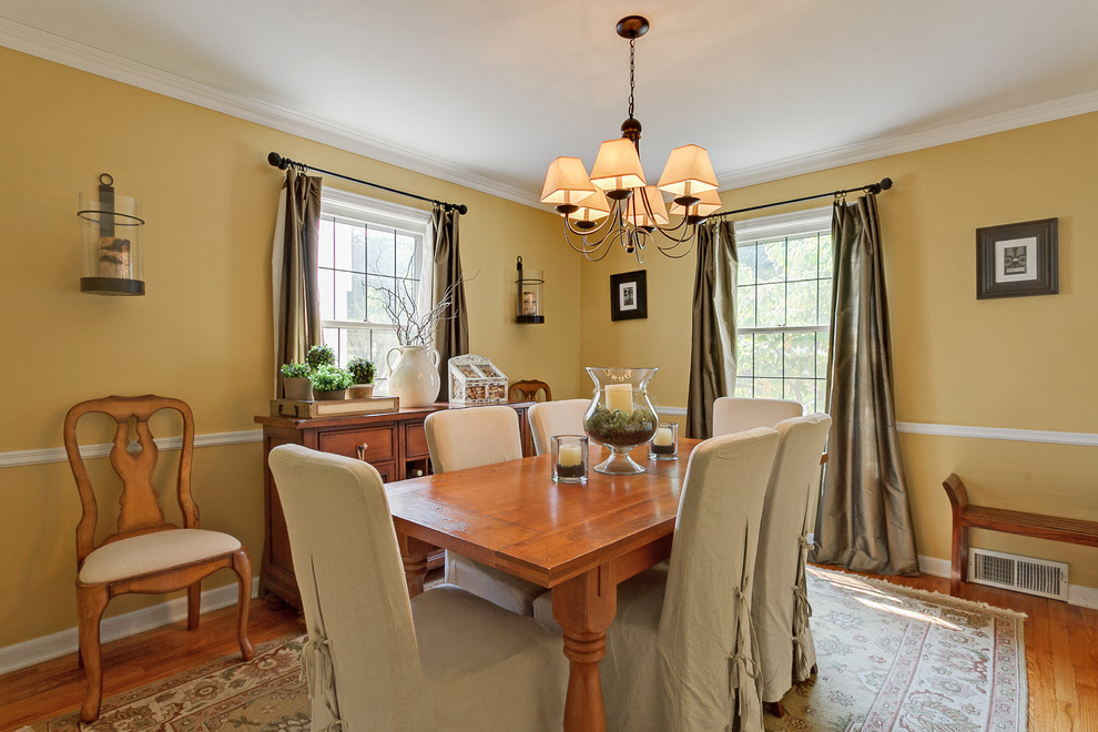 Inspiration for a timeless dining room remodel in Columbus with yellow walls