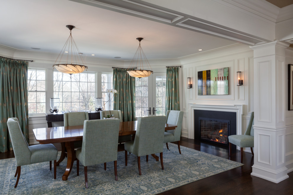 Inspiration for a large classic enclosed dining room in Boston with white walls, dark hardwood flooring, a standard fireplace and a wooden fireplace surround.