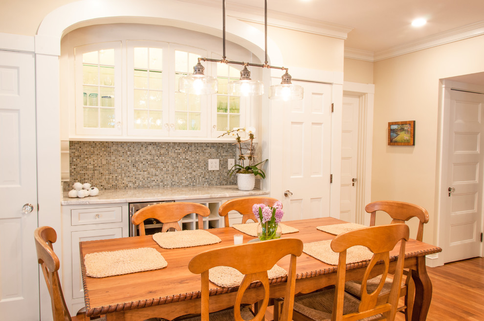 Immagine di una piccola sala da pranzo aperta verso la cucina classica con pavimento in legno massello medio, pareti bianche, nessun camino e pavimento marrone