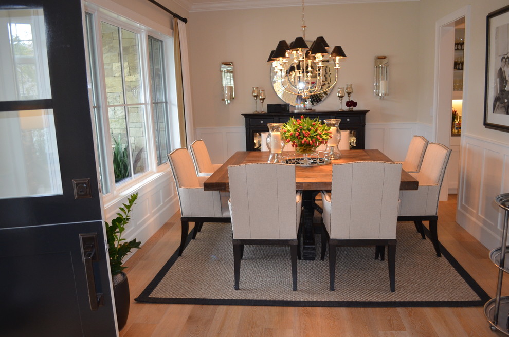 Example of a large transitional medium tone wood floor enclosed dining room design in Orange County with beige walls and no fireplace