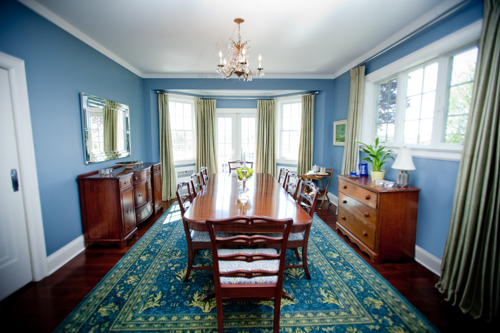 Foto di una sala da pranzo aperta verso la cucina country di medie dimensioni con pareti blu, pavimento in legno massello medio e nessun camino