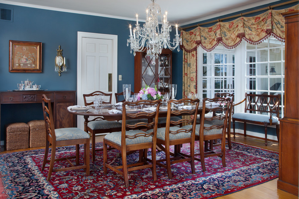 Idée de décoration pour une grande salle à manger tradition fermée avec un mur bleu et un sol en bois brun.