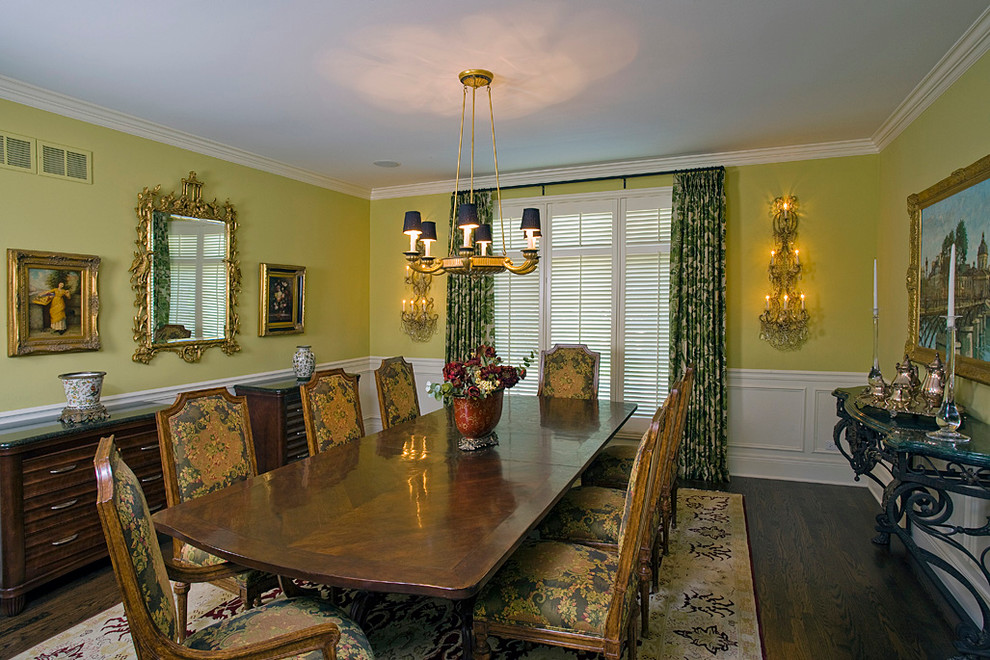 Стильный дизайн: огромная отдельная столовая в классическом стиле с желтыми стенами и темным паркетным полом - последний тренд