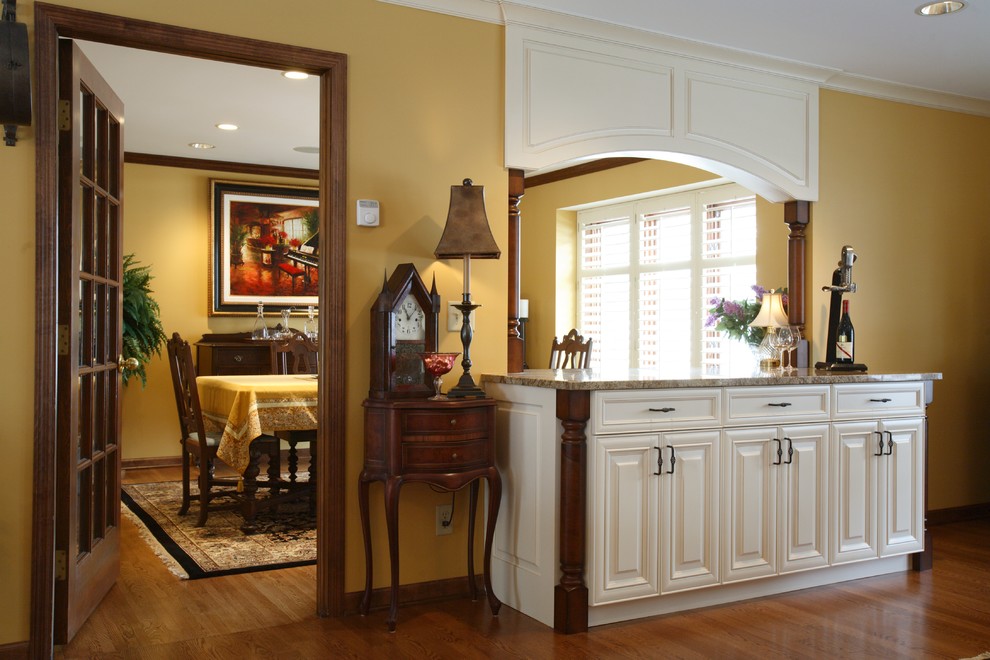Cette image montre une salle à manger ouverte sur le salon traditionnelle de taille moyenne avec un mur jaune et un sol en bois brun.