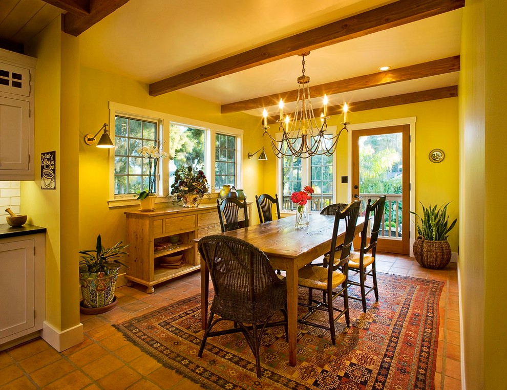 Immagine di una sala da pranzo tradizionale chiusa e di medie dimensioni con pareti gialle e pavimento in terracotta