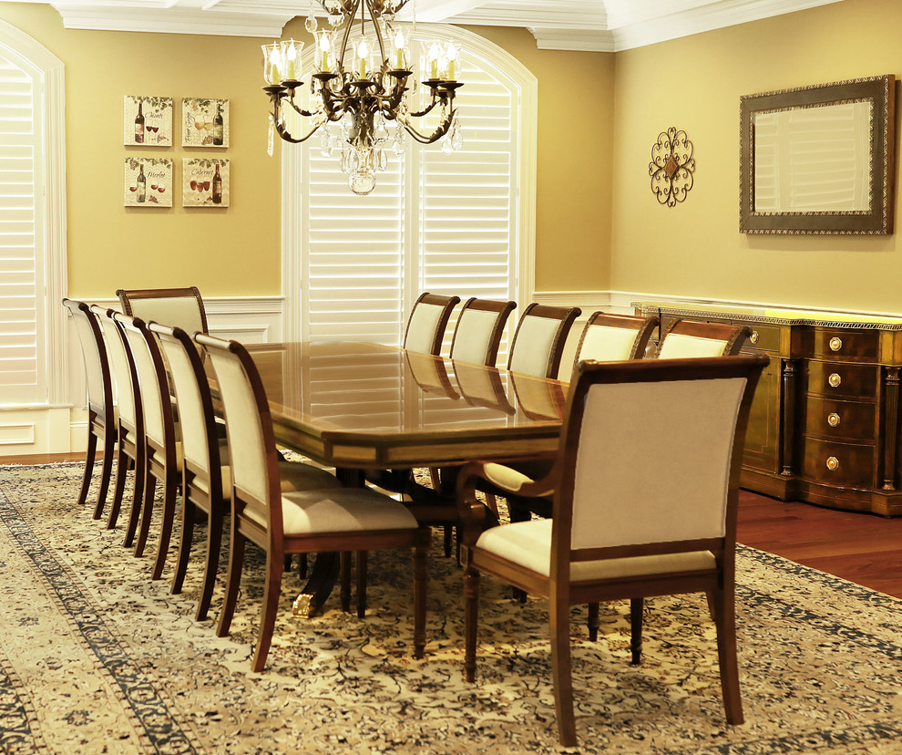 Ispirazione per una grande sala da pranzo aperta verso la cucina classica con pareti gialle, pavimento in legno massello medio e pavimento marrone