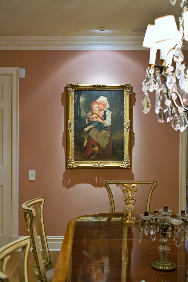 Modelo de comedor clásico de tamaño medio cerrado con paredes rosas y suelo de madera clara