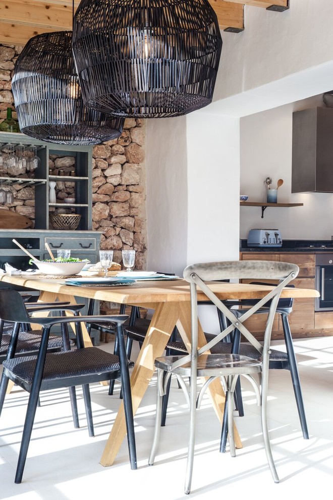 Immagine di una sala da pranzo aperta verso la cucina mediterranea con pavimento in cemento e pavimento beige