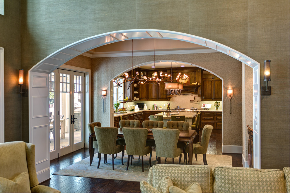 Inspiration pour une grande salle à manger ouverte sur le salon traditionnelle avec un mur beige, parquet foncé, une cheminée standard, un manteau de cheminée en pierre et un sol marron.