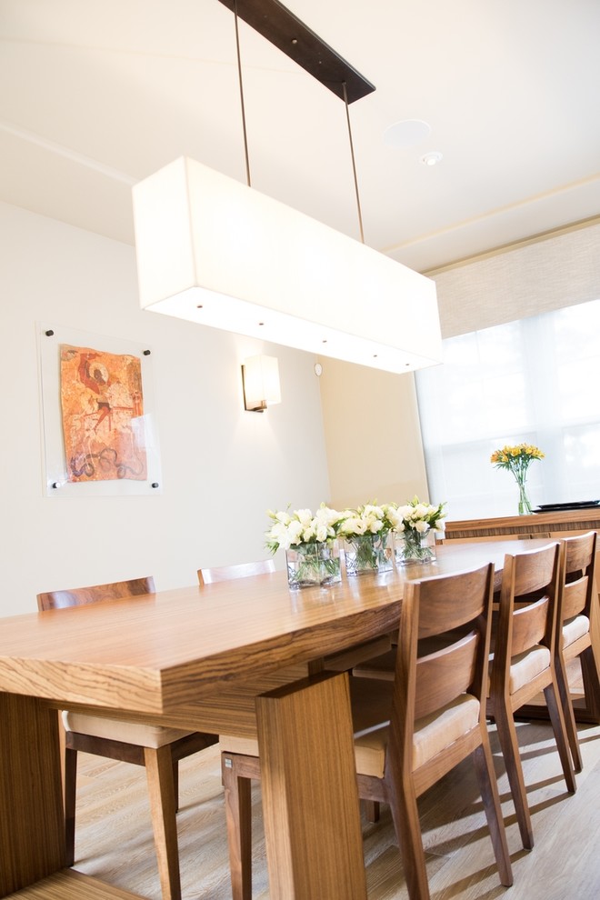 Foto di una sala da pranzo contemporanea chiusa con pareti bianche, parquet chiaro e soffitto ribassato