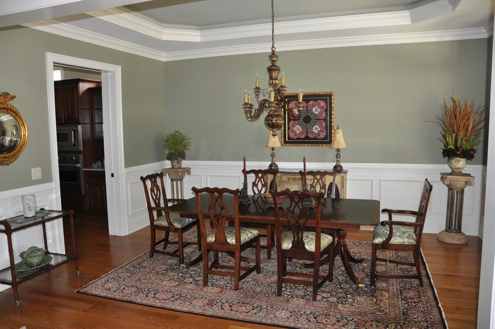 Mittelgroßes, Geschlossenes Klassisches Esszimmer mit grüner Wandfarbe, braunem Holzboden, braunem Boden, eingelassener Decke und vertäfelten Wänden in Raleigh