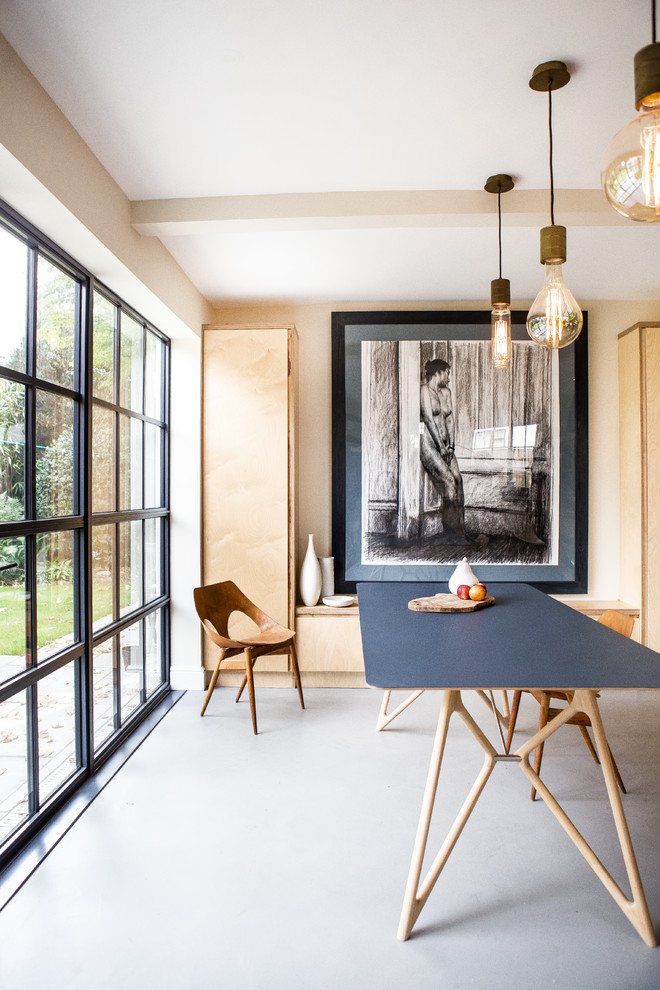 This is an example of a scandinavian dining room in Oxfordshire with no fireplace and grey floors.