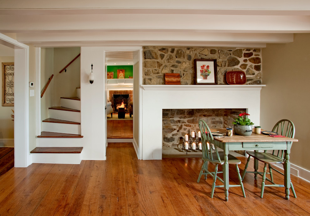Aménagement d'une grande salle à manger ouverte sur le salon campagne avec un mur beige, parquet foncé, une cheminée standard et un manteau de cheminée en pierre.