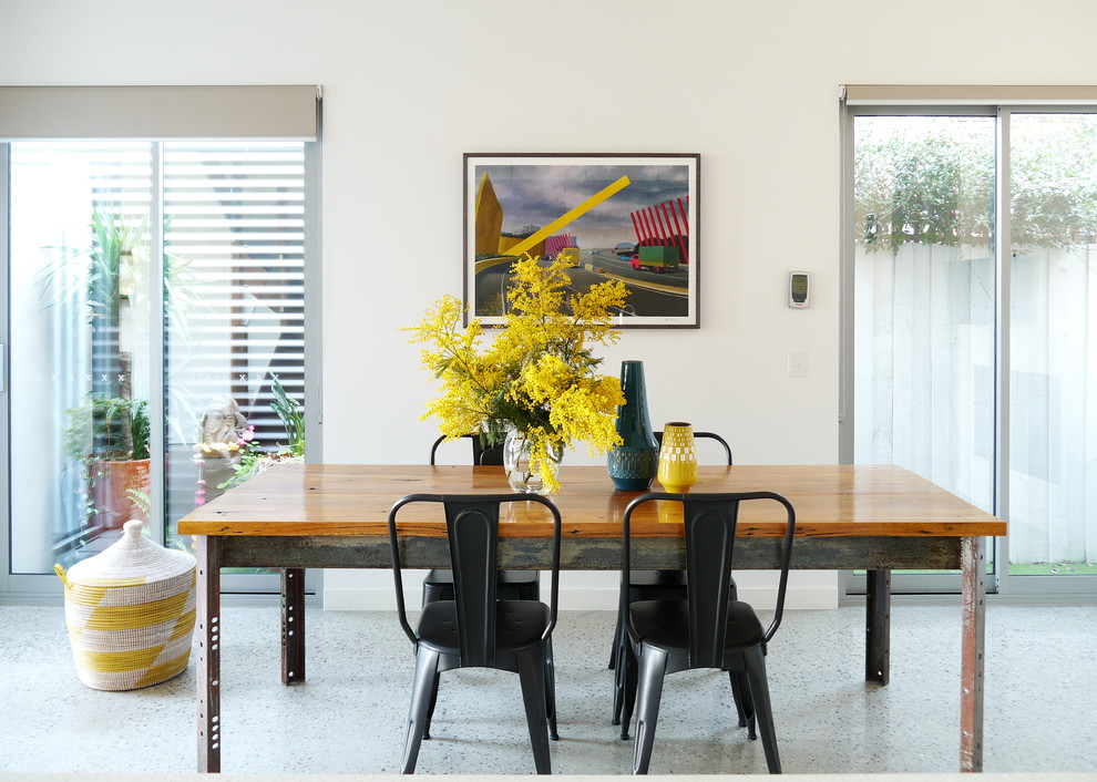 На фото: столовая в стиле неоклассика (современная классика) с белыми стенами и бетонным полом с