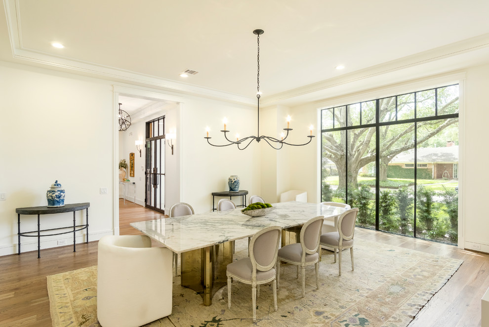 Inspiration for a transitional medium tone wood floor and brown floor enclosed dining room remodel in Houston with white walls