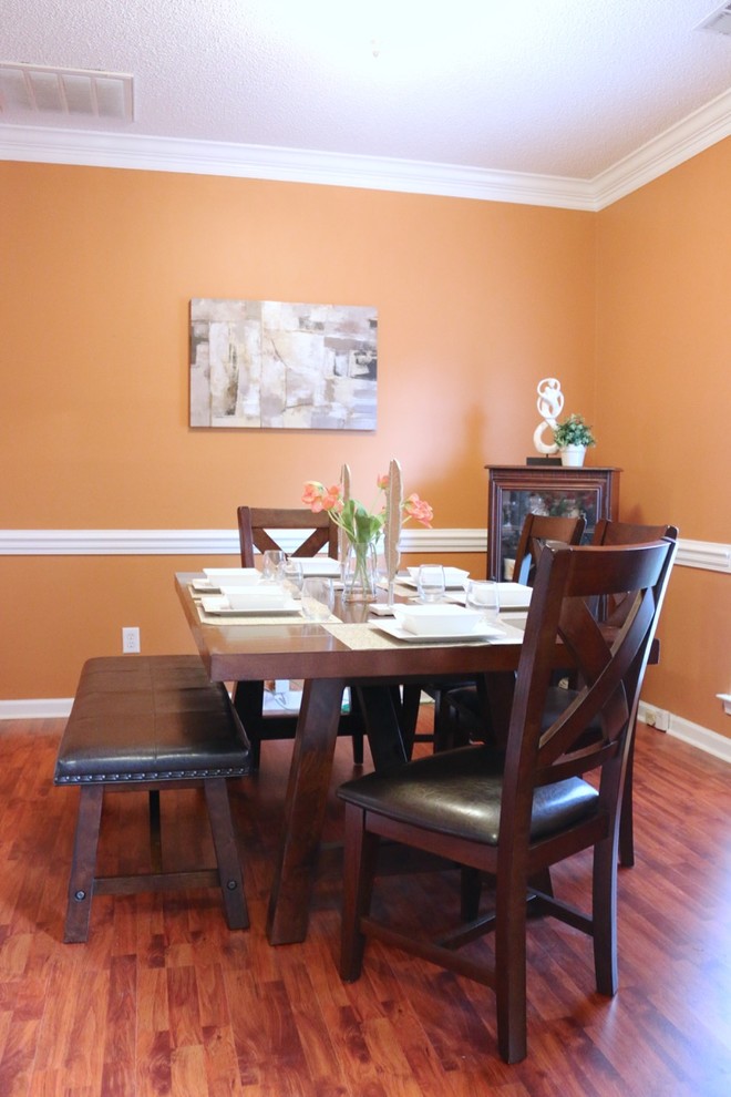 Esempio di una sala da pranzo tradizionale chiusa con pareti arancioni e pavimento in legno massello medio