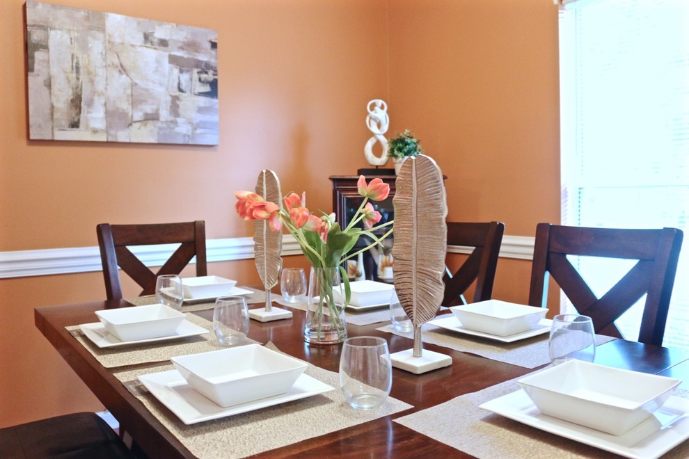 Foto de comedor clásico renovado cerrado con parades naranjas y suelo de madera en tonos medios