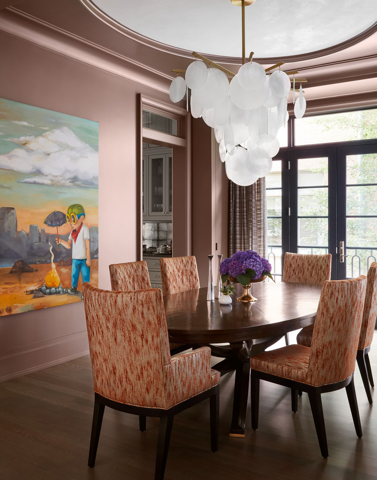 Immagine di una sala da pranzo classica con pareti rosa, pavimento in legno massello medio e pavimento marrone