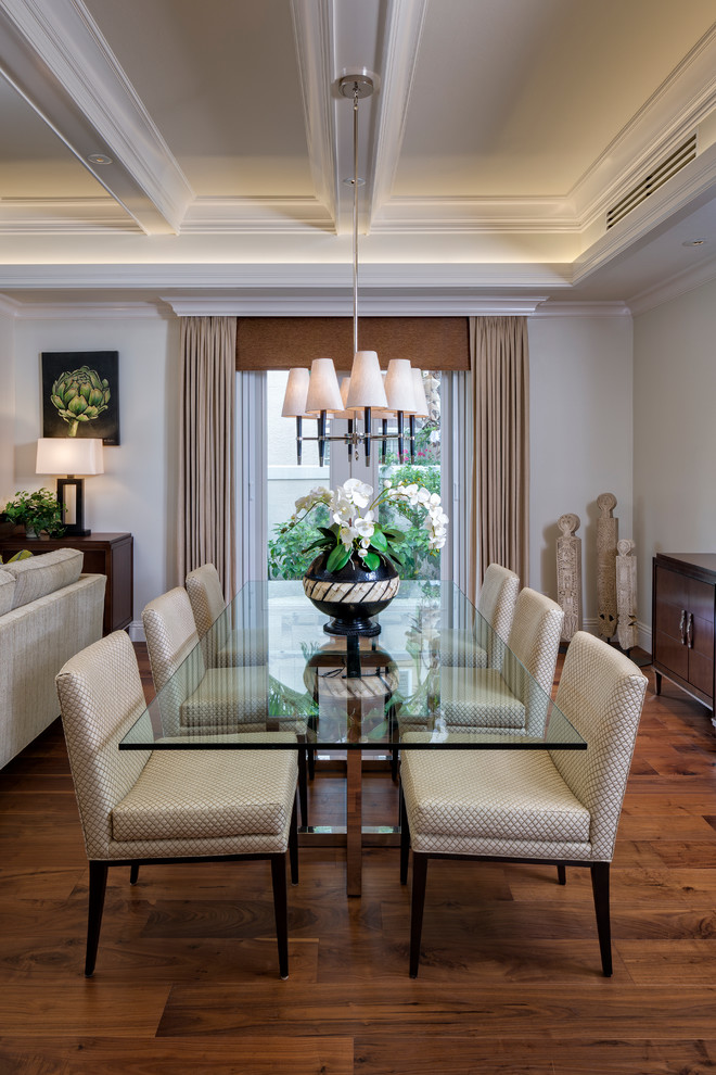 Photo of a traditional open plan dining room in Miami with beige walls, dark hardwood flooring and feature lighting.