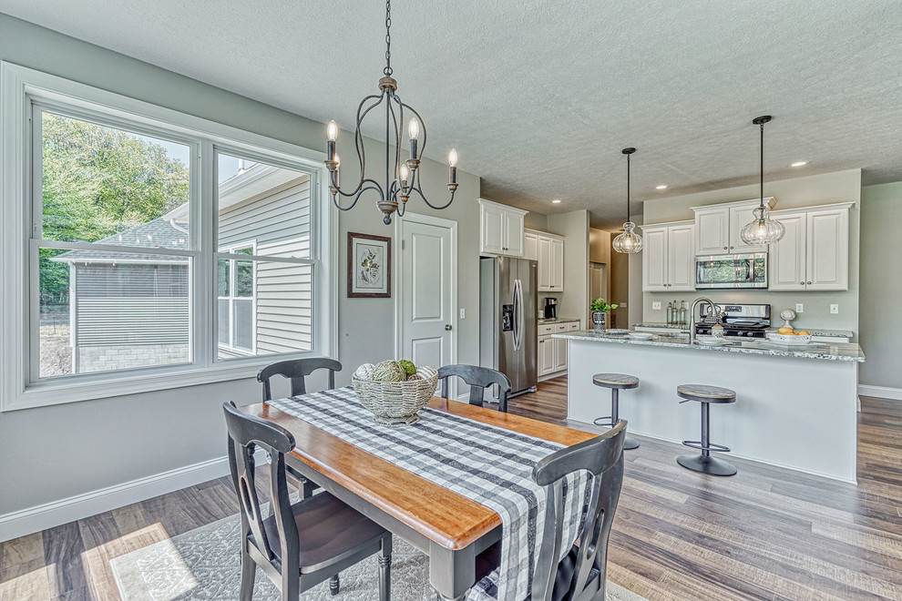 Example of a large transitional medium tone wood floor and multicolored floor kitchen/dining room combo design in New York with gray walls