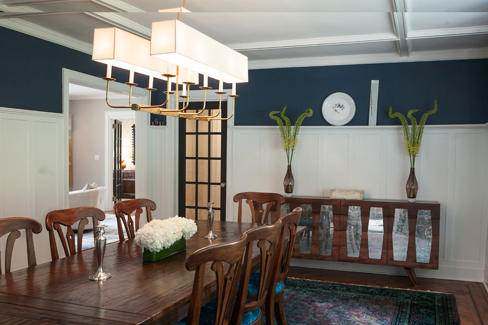 Cette image montre une grande salle à manger traditionnelle fermée avec un mur bleu et parquet foncé.
