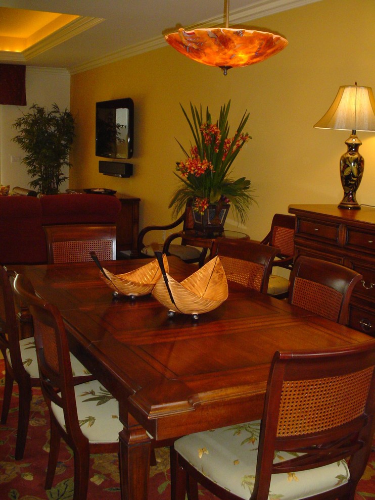 Esempio di una sala da pranzo aperta verso il soggiorno tropicale con pareti gialle e pavimento in pietra calcarea