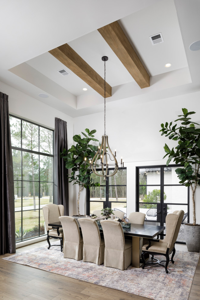 Inspiration for a medium sized classic open plan dining room in Houston with white walls, laminate floors, exposed beams, a drop ceiling and brown floors.