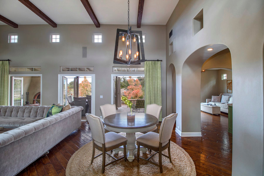 This is an example of a large traditional open plan dining room in San Diego with grey walls, dark hardwood flooring, brown floors, a standard fireplace and a plastered fireplace surround.