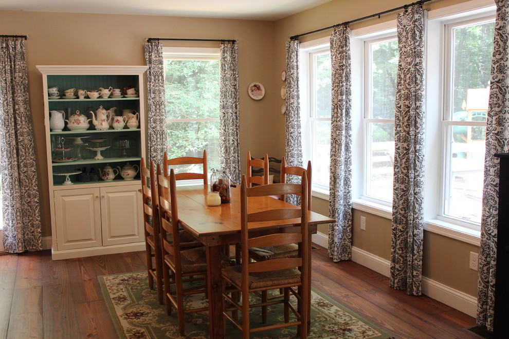 Immagine di una sala da pranzo aperta verso il soggiorno country di medie dimensioni con pareti marroni, pavimento in legno massello medio e nessun camino
