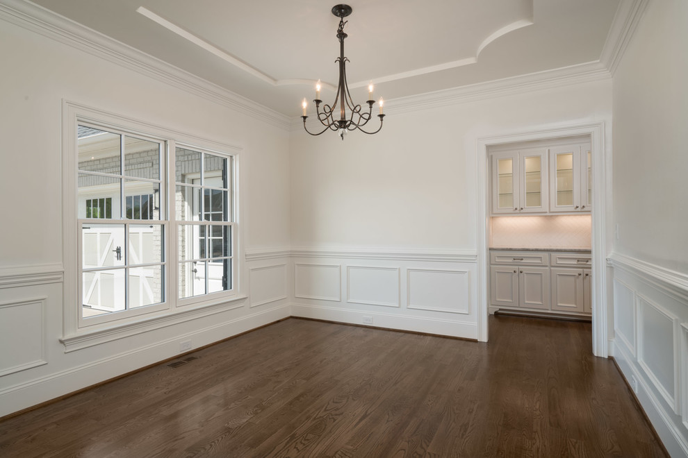 Large classic dining room in Other with grey walls and dark hardwood flooring.
