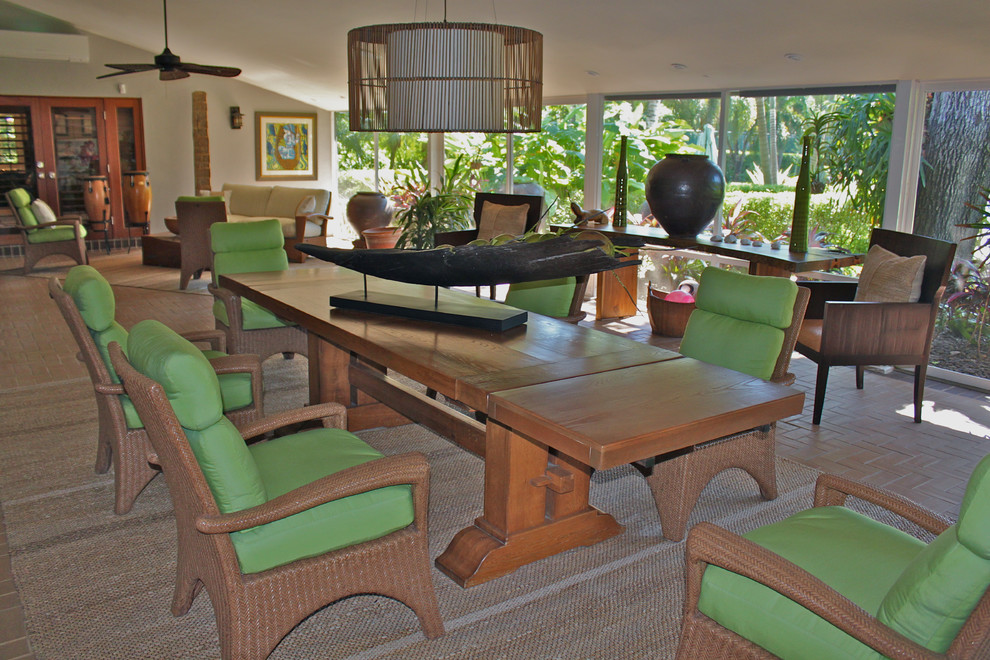 Foto di una sala da pranzo aperta verso il soggiorno tropicale con pareti beige