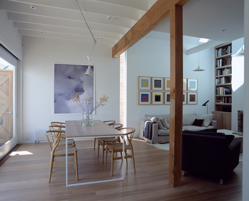 Diseño de comedor moderno de tamaño medio abierto con paredes blancas y suelo de madera clara