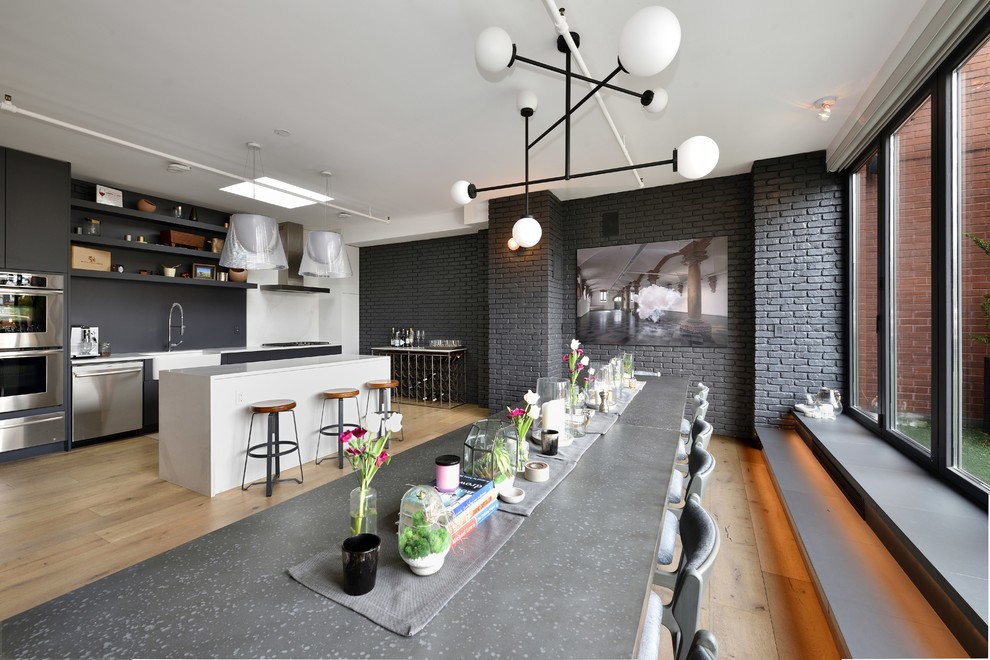 Exemple d'une salle à manger ouverte sur la cuisine tendance de taille moyenne avec un mur gris, parquet clair, aucune cheminée et un sol beige.