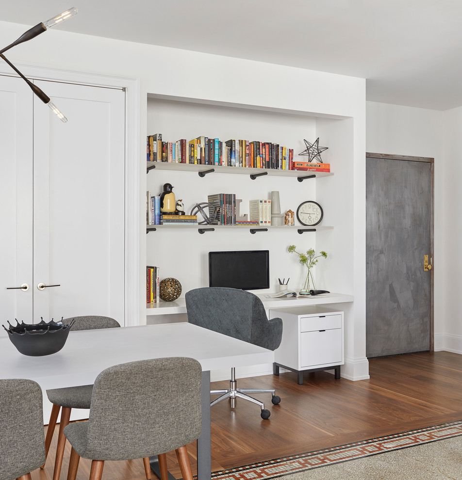 Inspiration pour une salle à manger ouverte sur la cuisine design de taille moyenne avec un mur blanc et un sol en bois brun.