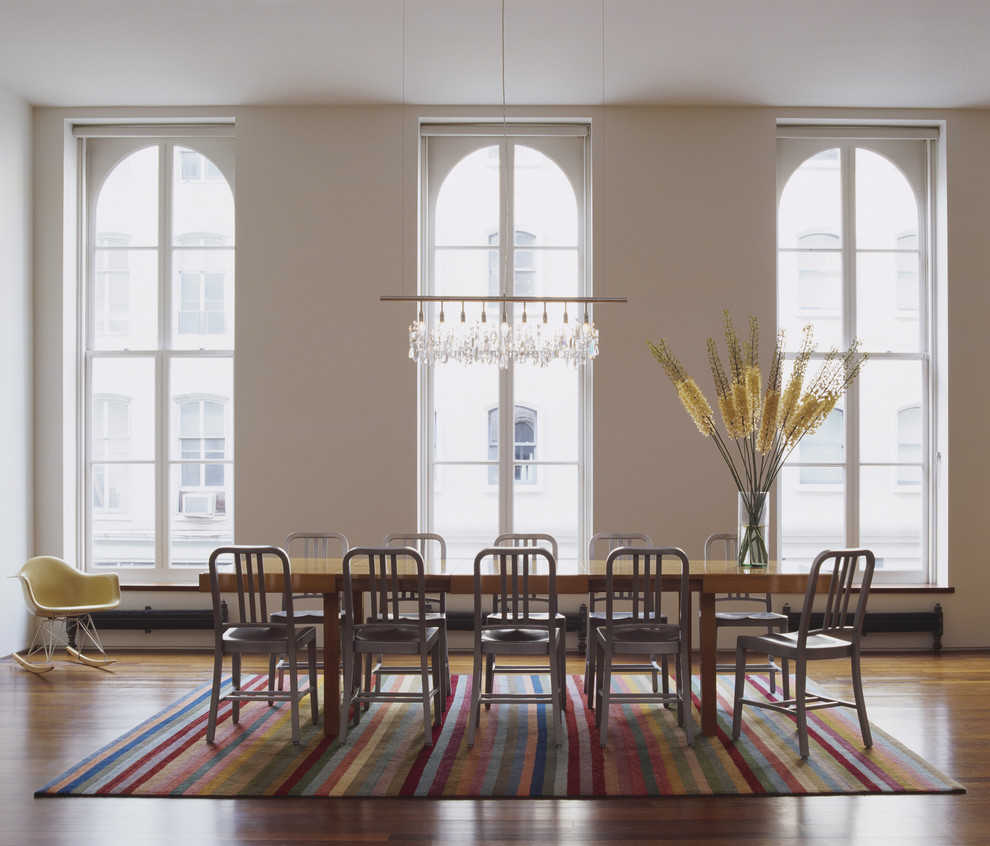 Foto di un'ampia sala da pranzo aperta verso il soggiorno minimal con pareti bianche e parquet scuro